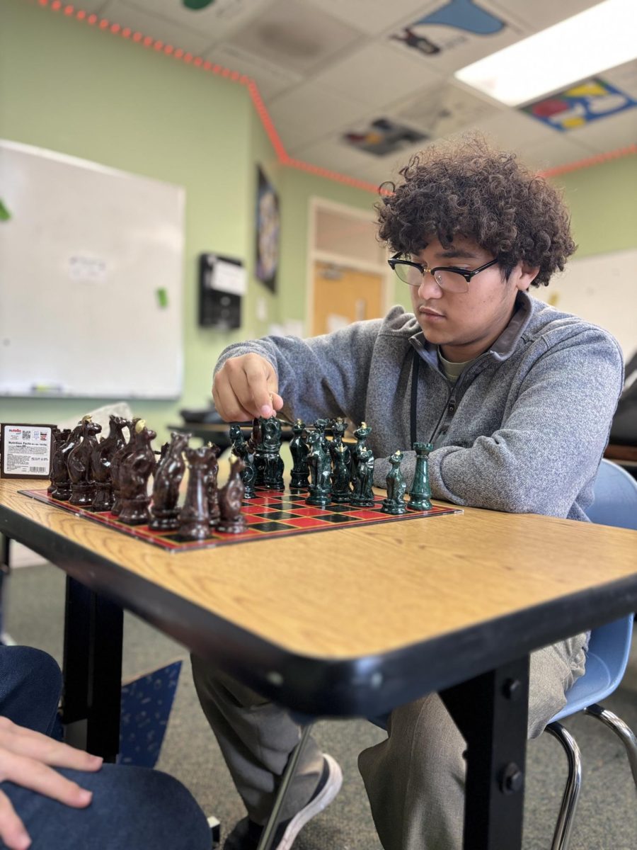 Christian Ibarra, chess club leader, playing chess against another chess club member. 